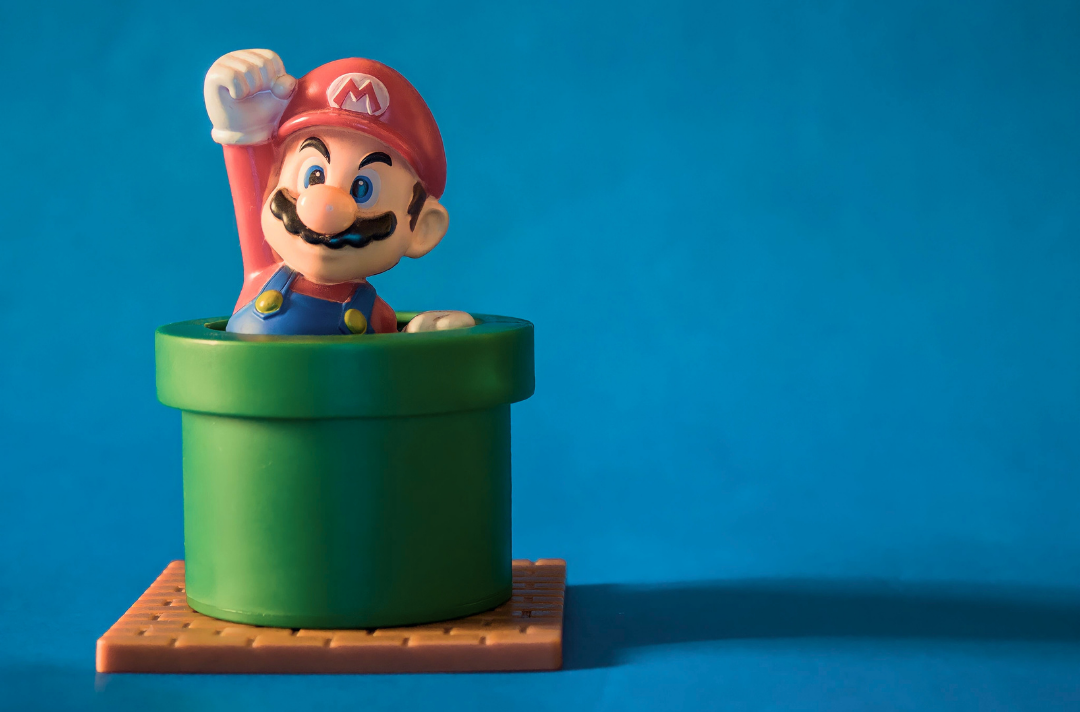 A figure shows Mario leaping from a pipe.