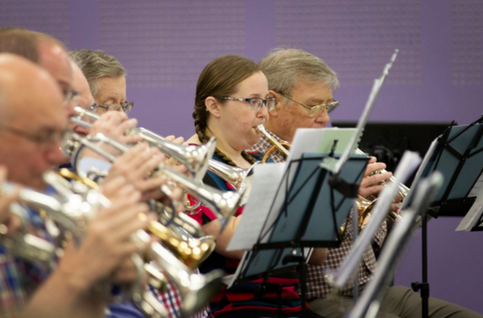 A row of people playing the cornet