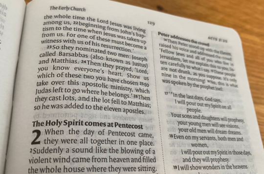 A photo of the Bible open at Acts 2: The Holy Spirit comes at Pentecost