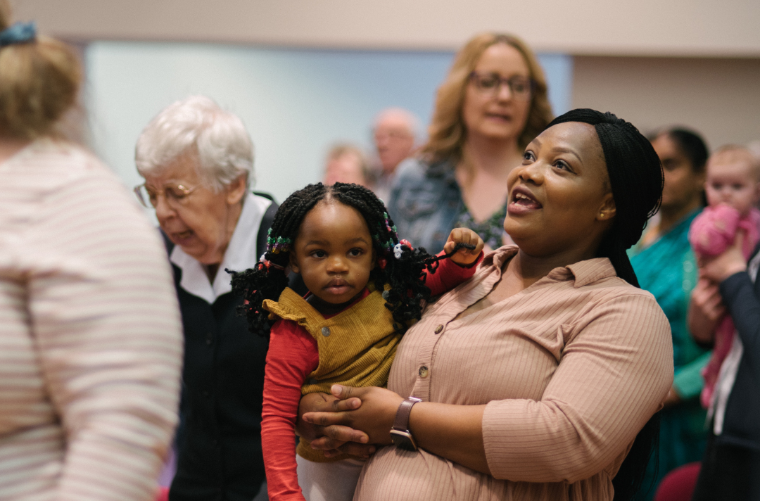A mother holding her child in a Salvation Army church congregation