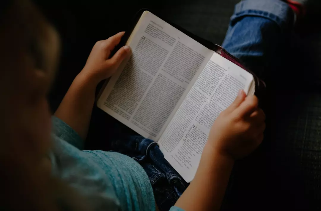 Stock image of someone reading the Bible