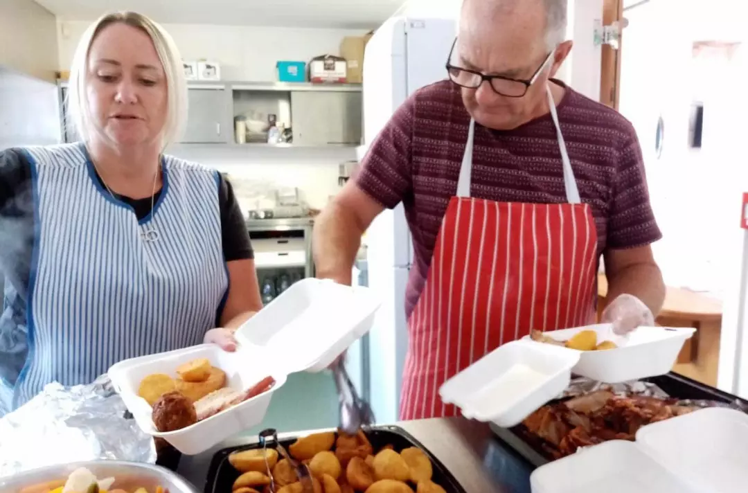 Volunteers serving takeaway meals