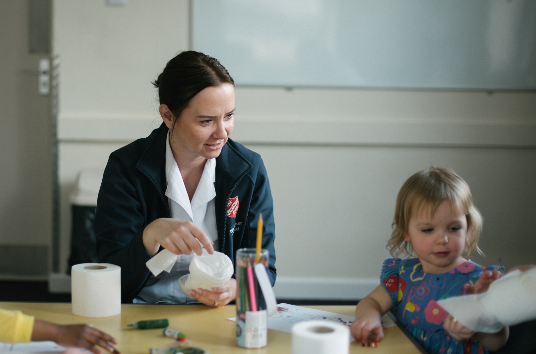 A Salvation Army children's worker making crafts with a toddler