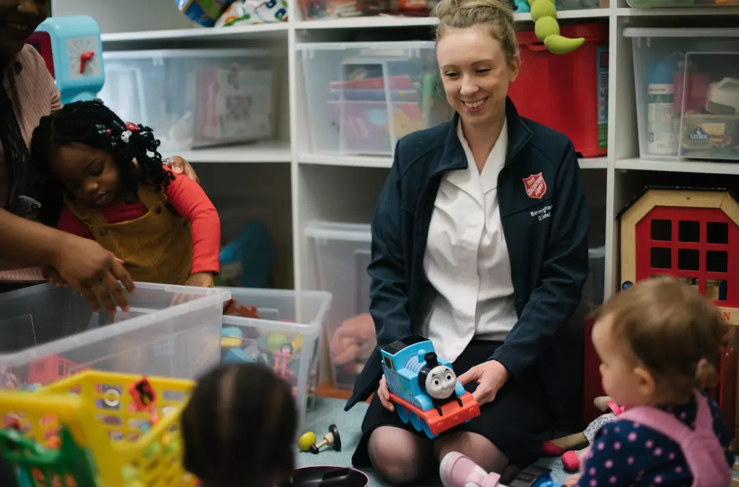 A Salvation Army children's worker playing with toddlers