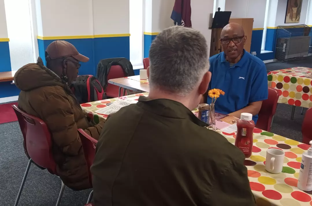 Dennis talking to two people at a table