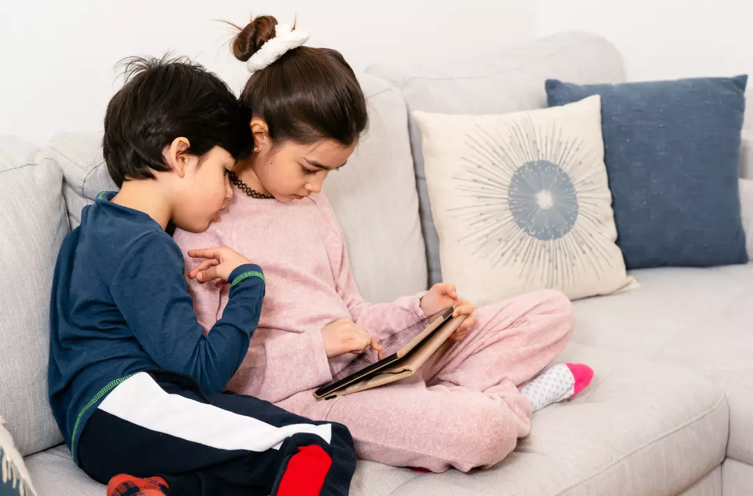Siblings playing on a tablet