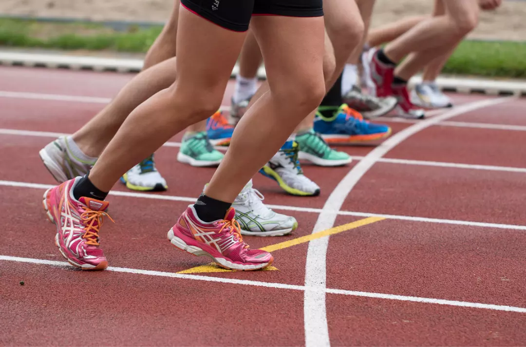 People lining up on an athletics track getting ready to start a race