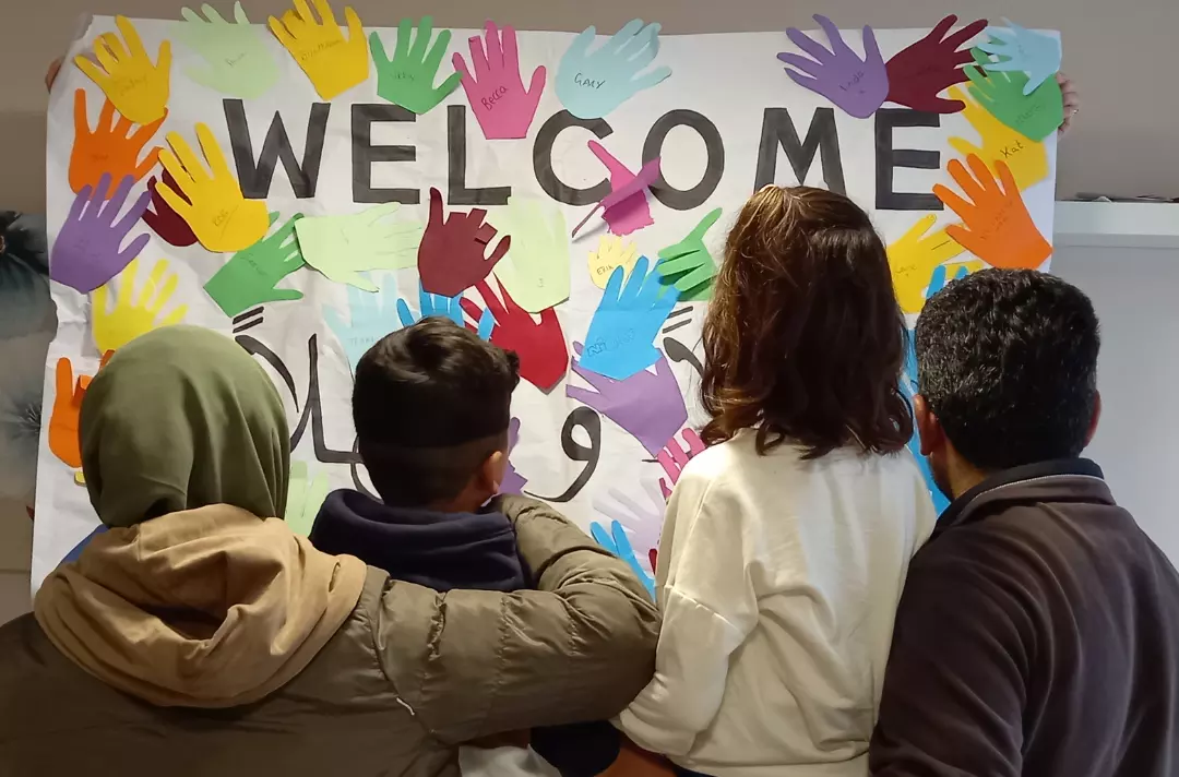A family looking at a welcome sign