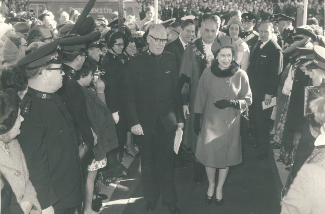 Queen Elizabeth II walking through a crowd of uniformed Salvationists