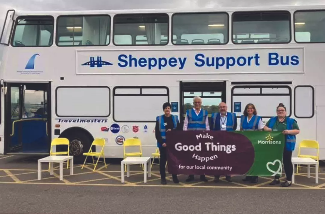 Partners standing outside the Sheppey Support Bus with a Morrisons supermarket banner