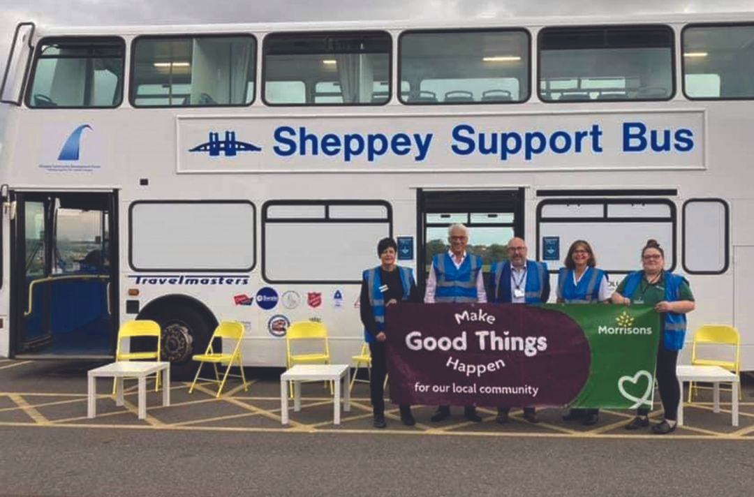 Partners standing outside the Sheppey Support Bus with a Morrisons supermarket banner