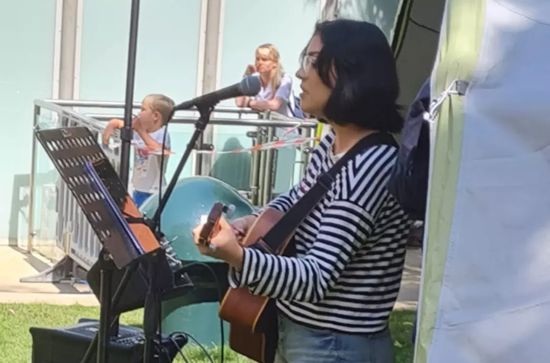 Someone singing and playing a guitar