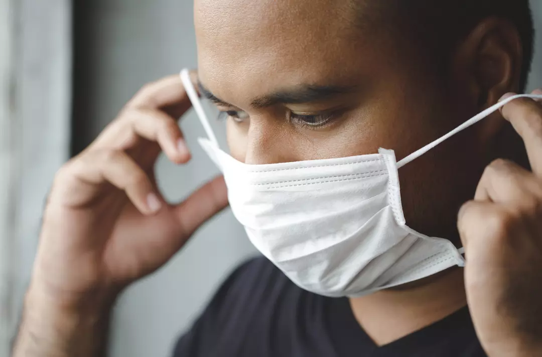 Someone putting on a face mask
