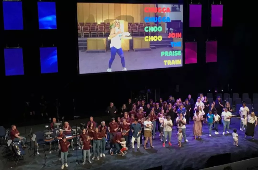 Adults, children and toddlers dance on stage