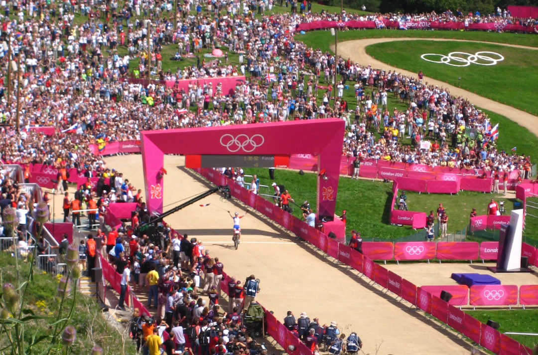 An Olympic mountain bike rider crossing the finish line at Hadleigh Farm