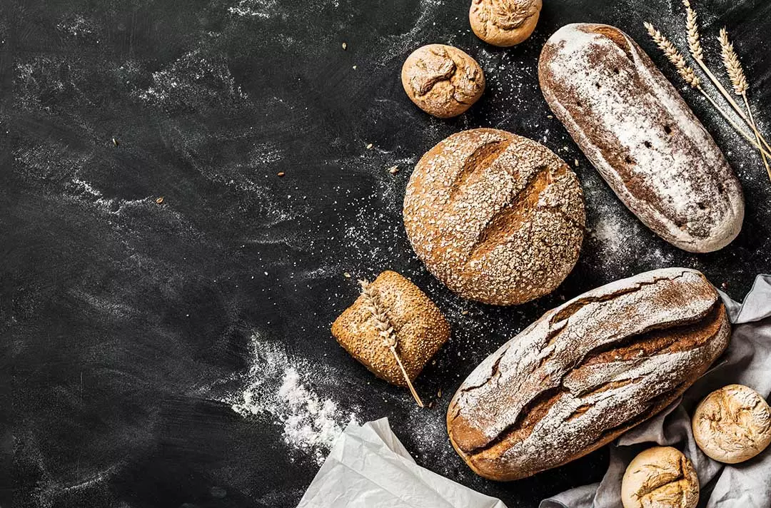 Loaves of bread on a table with flour