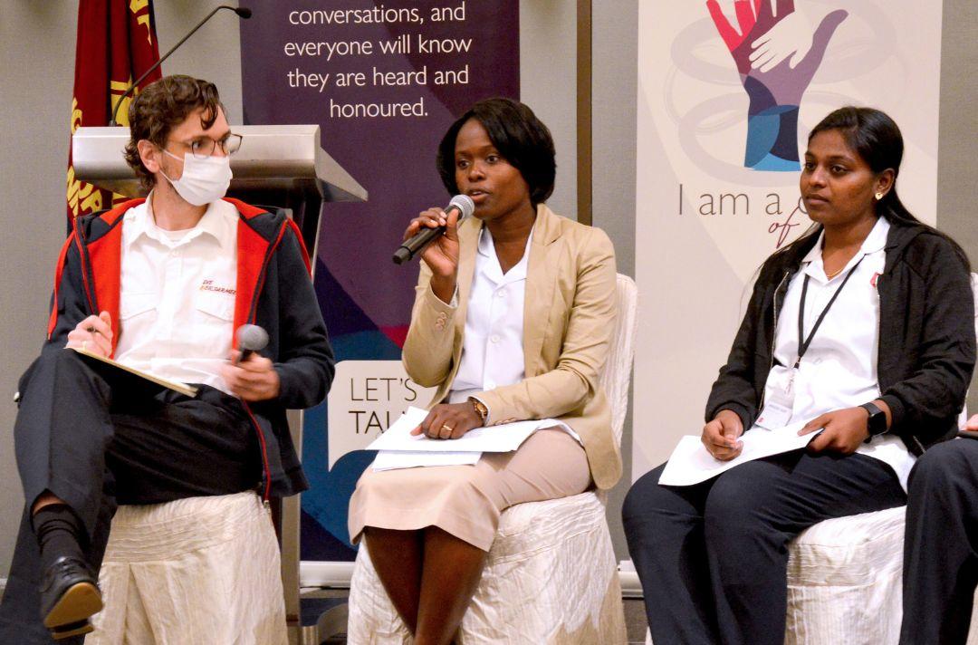 Delegates from Europe, Africa and Asia sitting in a panel and holding microphones