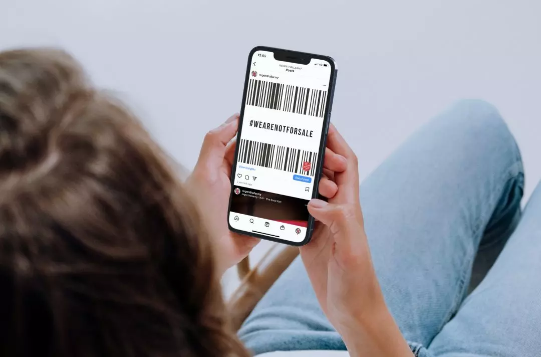 Someone looking at social media on their phone, viewing a #WeAreNotForSale barcode graphic