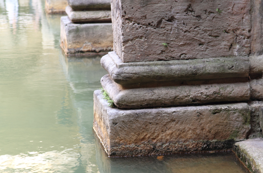 A old stone pillar and steps leading into water