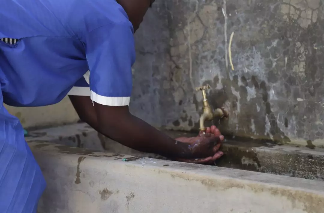 Someone washing there hands using an outside tap