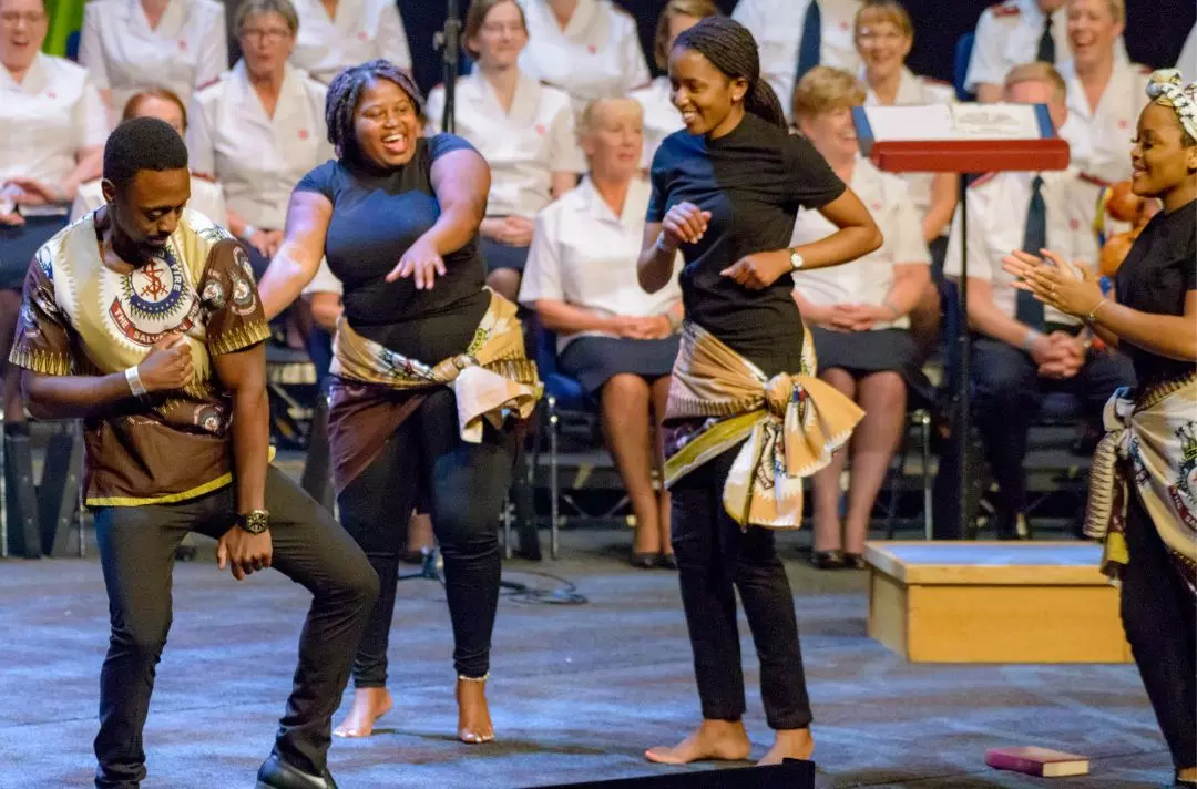 A group of young adults dancing in African Salvation Army uniform