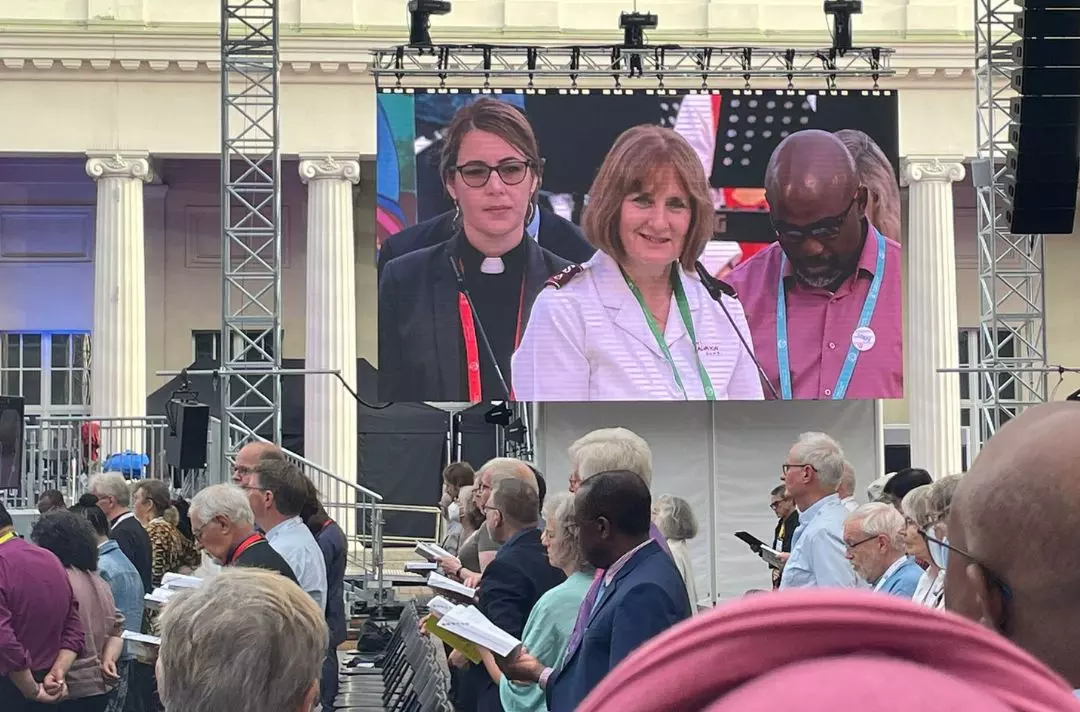 Commissioner Jane on a big screen speaking with a microphone