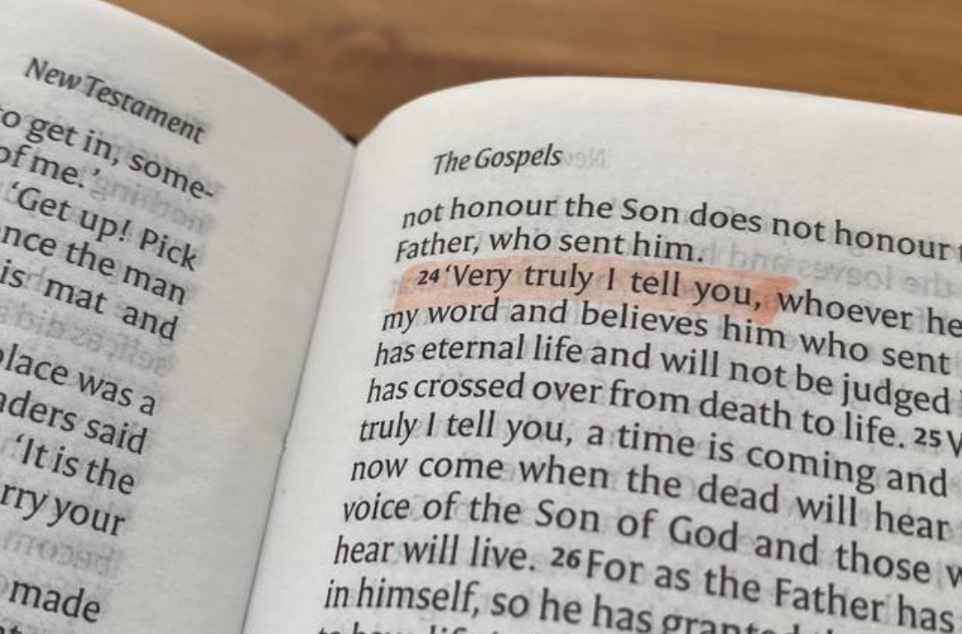 A photo of the Bible open at John 5 with the words 'Very truly I tell you' highlighted