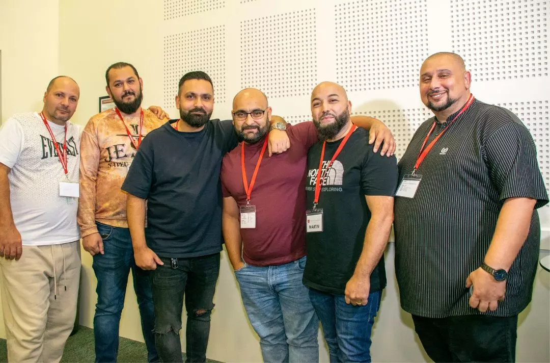 A group of six men at posing for a group photo a the conference