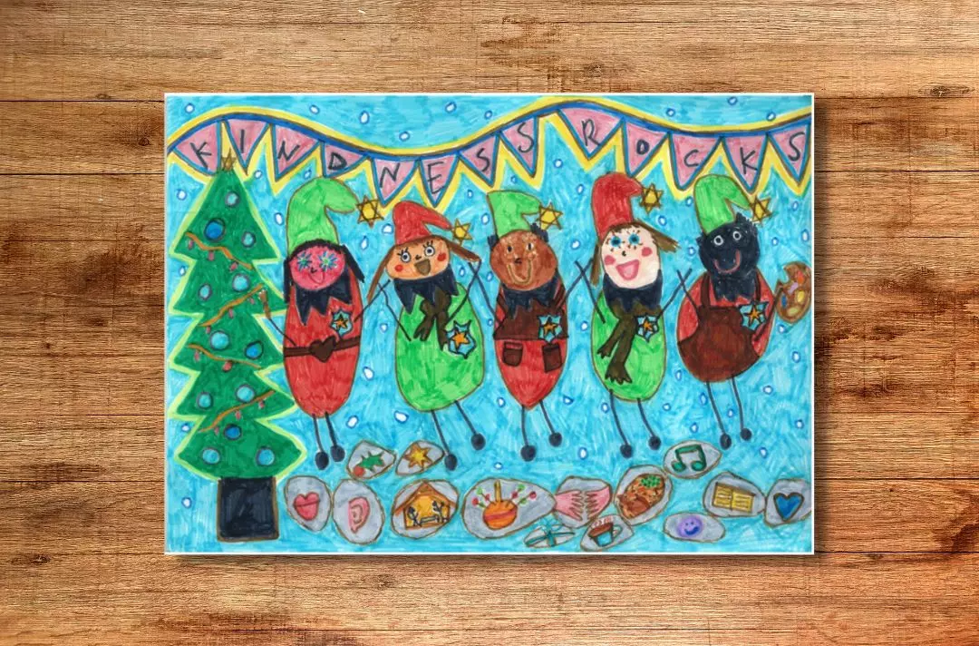 A copy of the winning card design from 2021: A child's drawing of a Christmas tree, bunting that spells 'kindness rocks', snow falling, a diverse group of people with festive hats on surrounded by icons depicting Christmas and kind acts such as the nativity and shaking hands