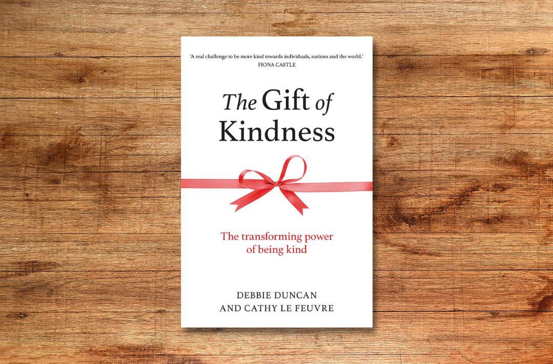 A photo of the The Gift of Kindness front cover featuring a red ribbon bow