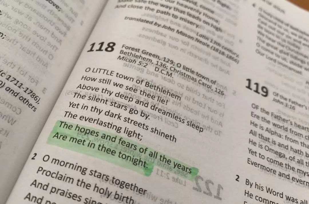 A photo of The Salvation Army Song Book open at the carol O Little Town of Bethlehem. The line 'The hopes and fears of all the years are met in thee tonight' is highlighted in green.