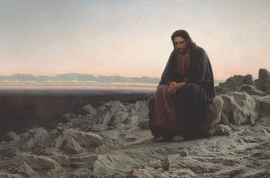A print of Christ in the Wilderness by Ivan Kramskoi - Jesus sits in a gloomy dessert surrounded by rocks with his hands clasped, looking down