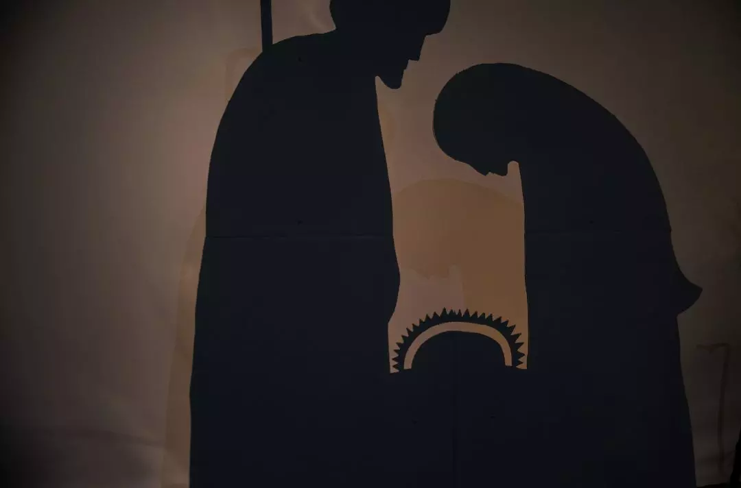 A silhouette of a nativity decoration featuring Mary, Joseph and Jesus in a manger