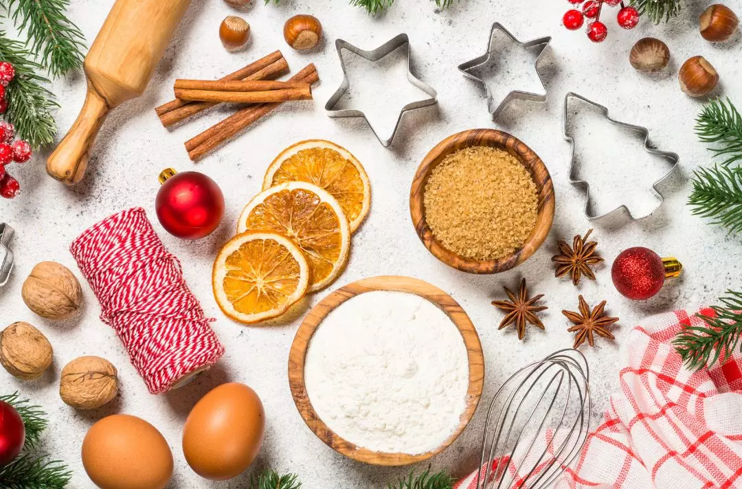 A photo of a kitchen table with Christmas decorations and baking utensils