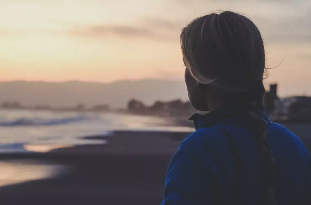 Someone looks out over a beach during sunrise or sunset