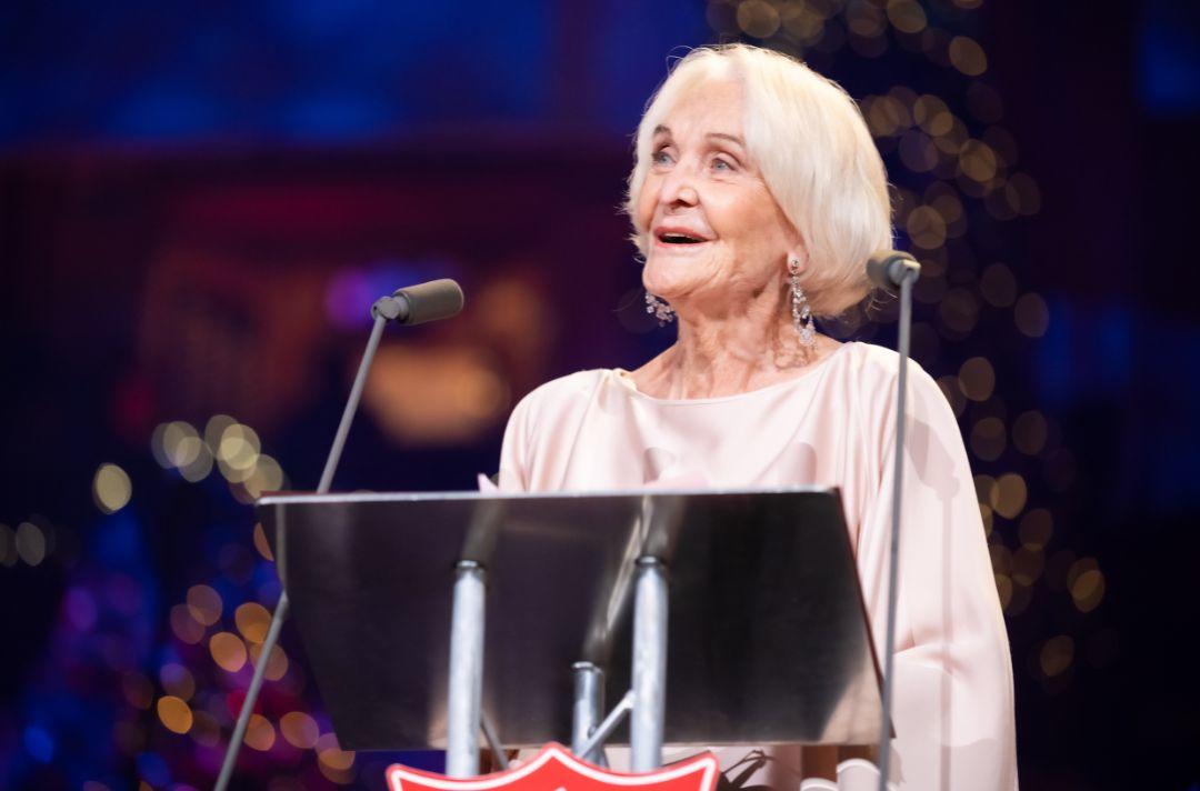 A photo of Sheila Hancock reading the Bible on the stage at the Royal Albert Hall
