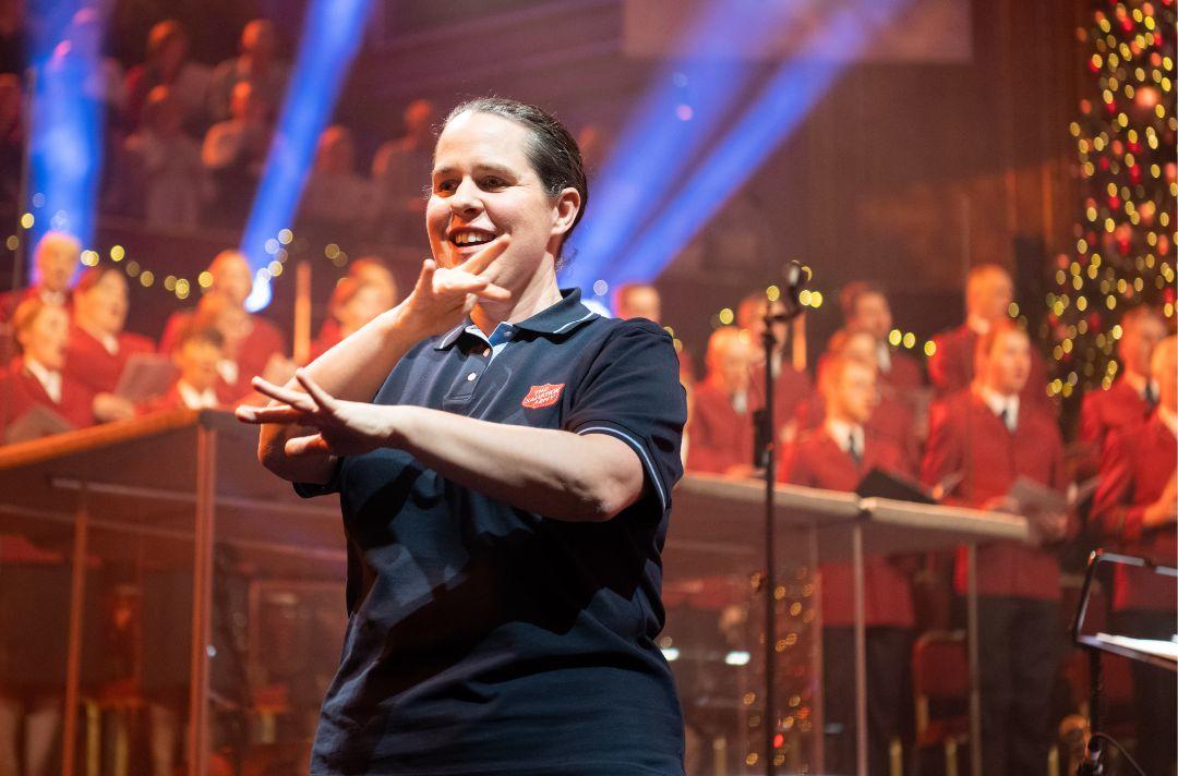 A photo of Sarah O'Grady signing on stage at the Royal Albert Hall