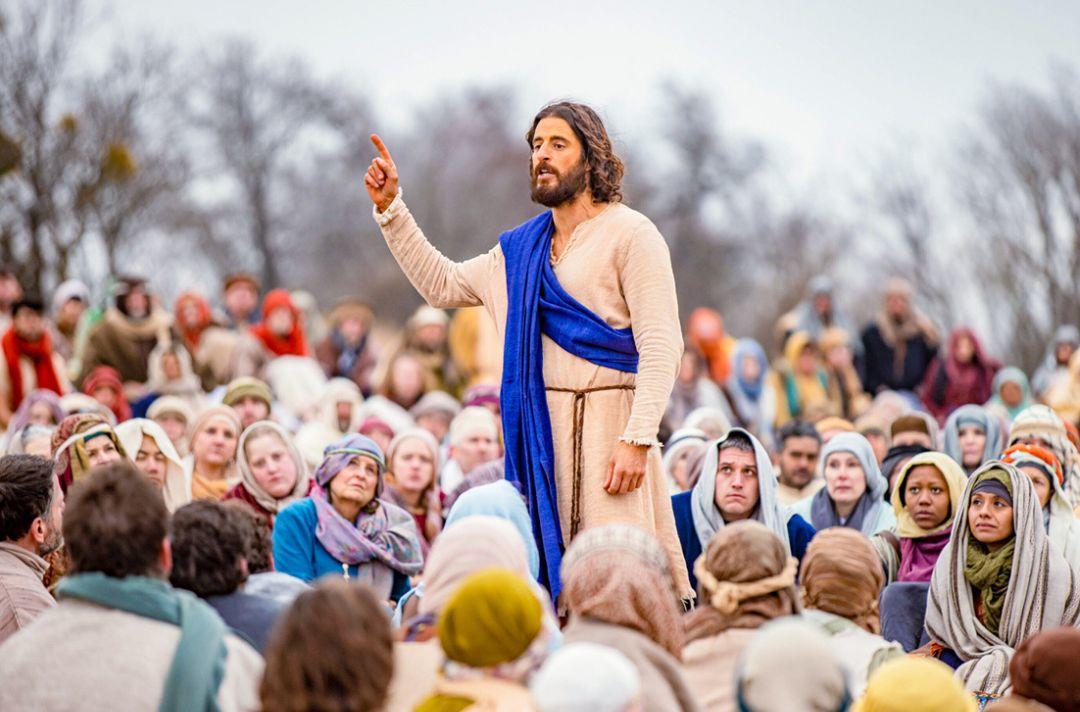 A photo from the TV series of Jesus preaching to a seated crowd