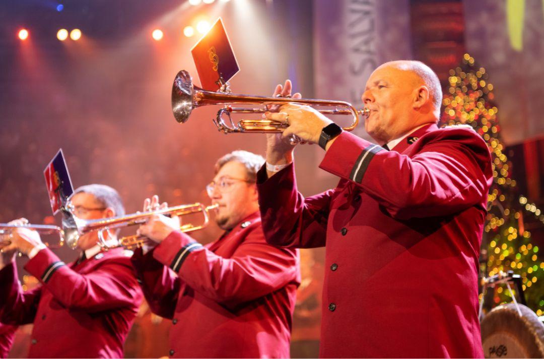 A photo of trumpeters wearing red Salvation Army uniforms performing on stage at the Royal Albert Hall