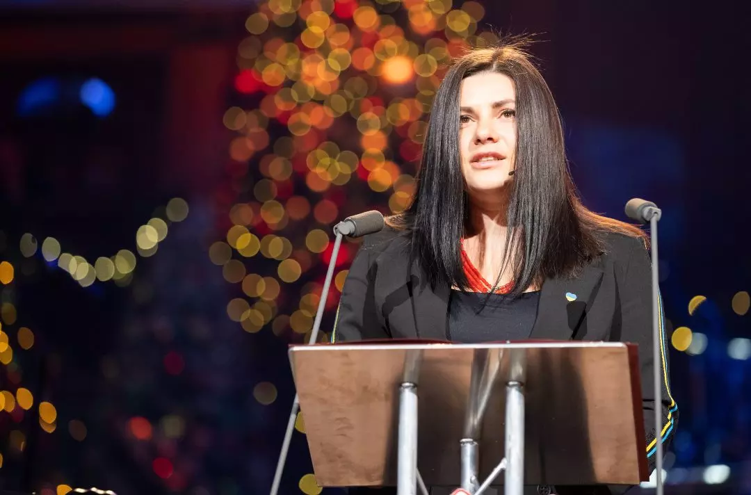 A photo of Bohdana speaking on stage at the Royal Albery Hall
