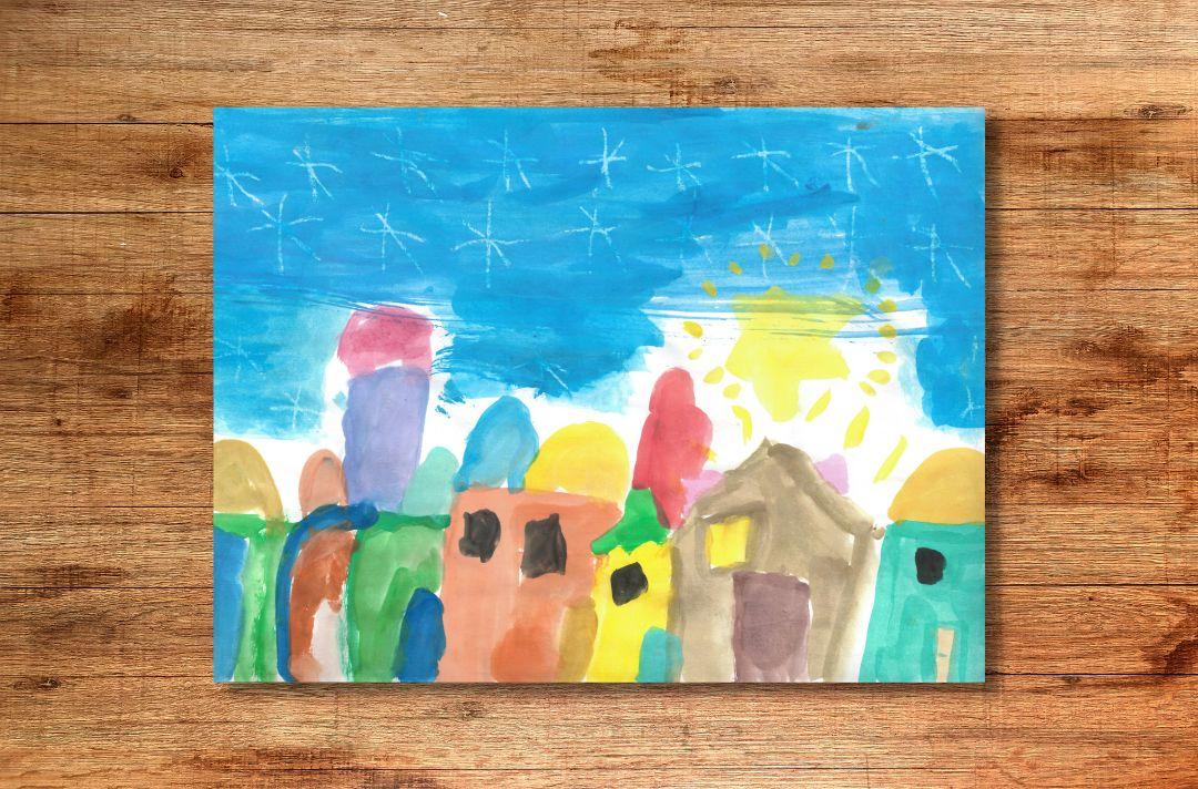 A Christmas card designed by a child, featuring a painting of a colourful town at night with a big yellow star in the sky and lots of smaller stars