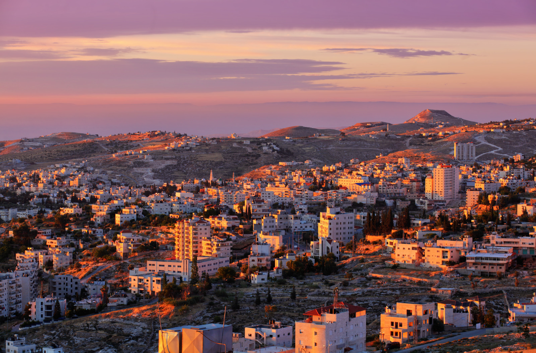 Photo shows an overview of modern-day Bethlehem at sunset or sunrise
