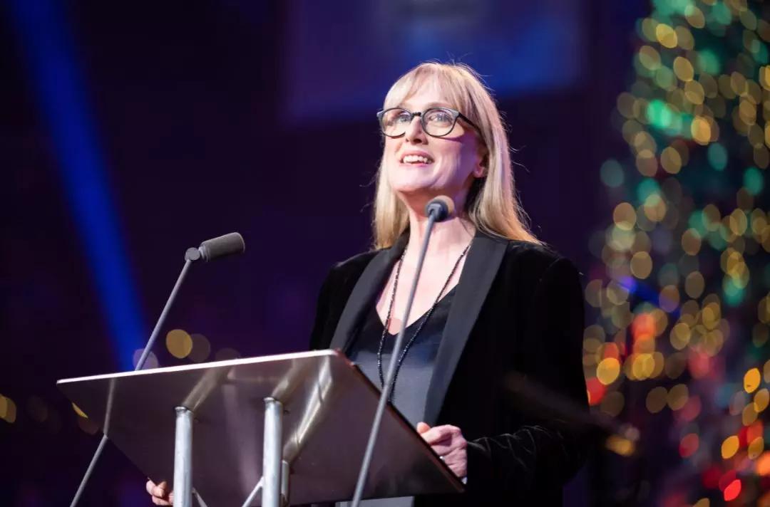 A photo of Jenna Russell reading the Bible on the stage of the Royal Albert Hall
