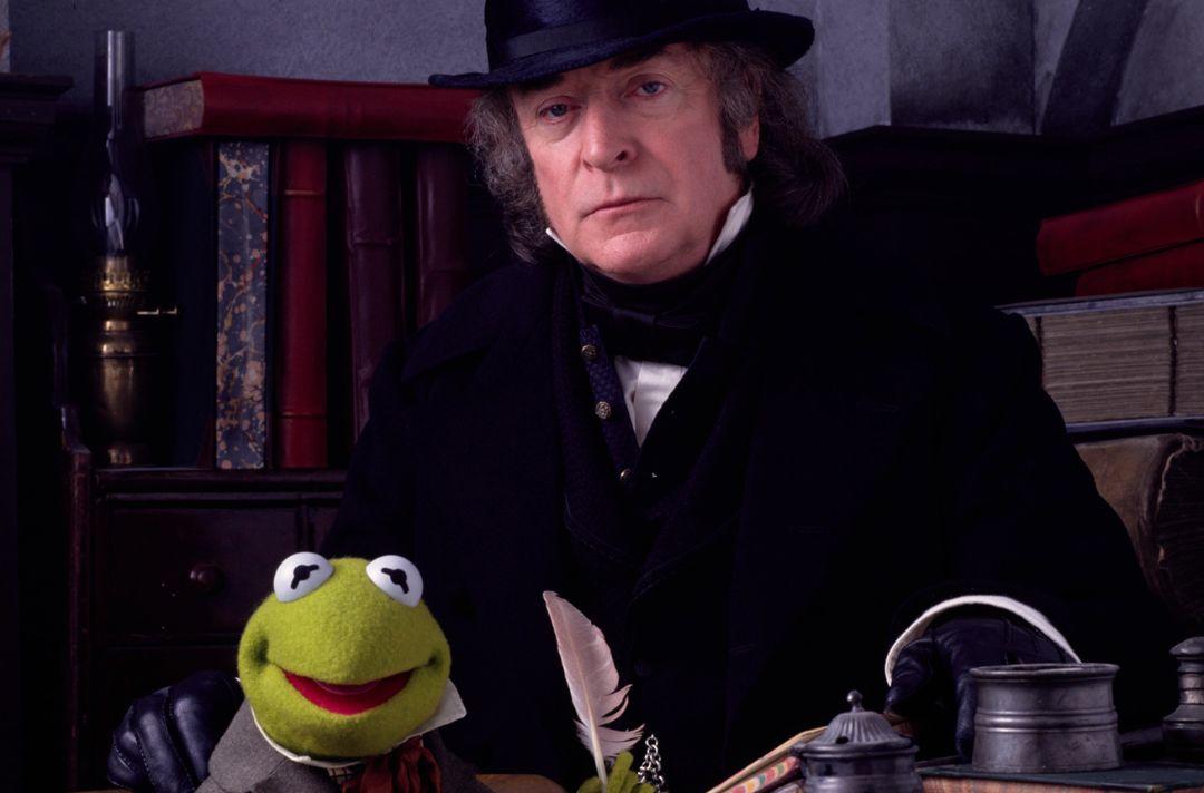 A staged photo of Michael Cane, as Scrooge, with his hand on Kermit the Frog, as Bob Cratchit