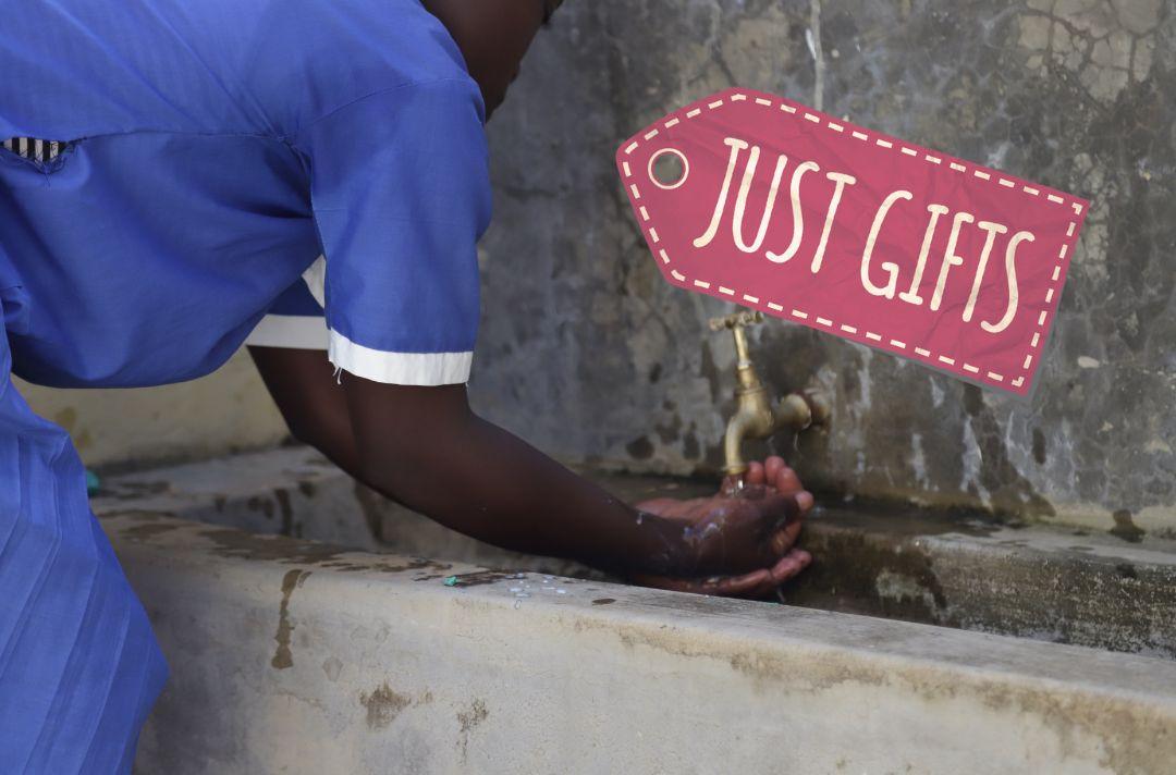A photo of a black person washing their hands at an outdoor sink with a logo for the Just Gifts scheme