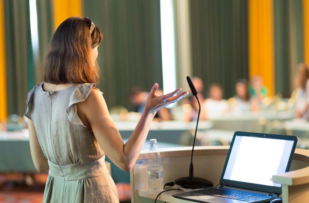 A photo of a university student giving a presentation in a university lecture theatre