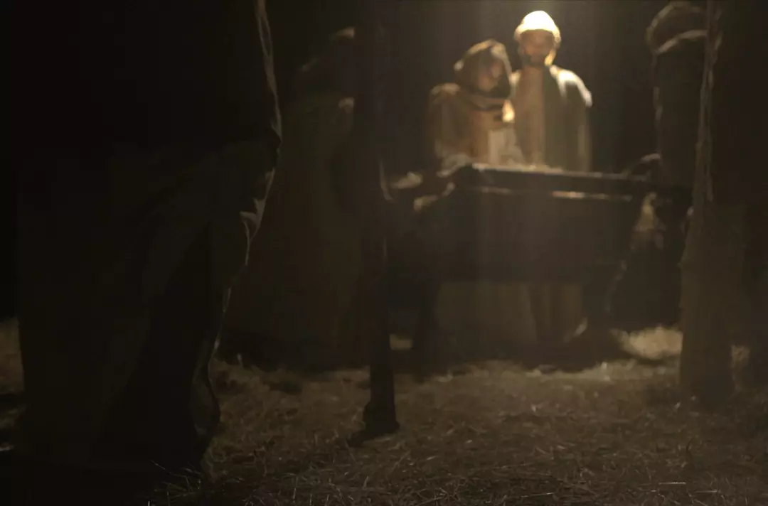 Photo shows someone approaching the manger scene.