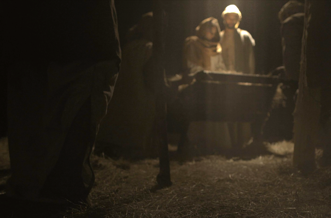 Photo shows someone approaching the manger scene.