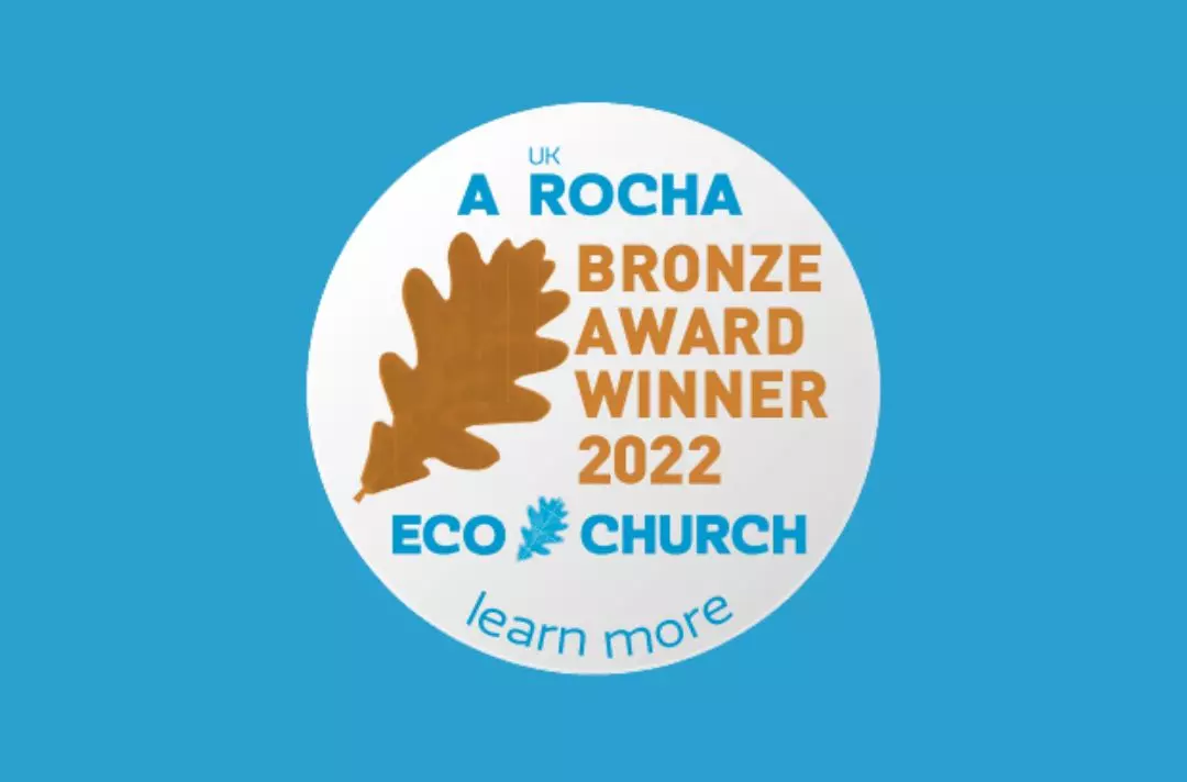 A graphic showing a Eco Church Bronze award sticker featuring a brown leaf. The text reads: 'A Rocha UK Bronze Award Winner 2022. Eco Church. Learn more.'