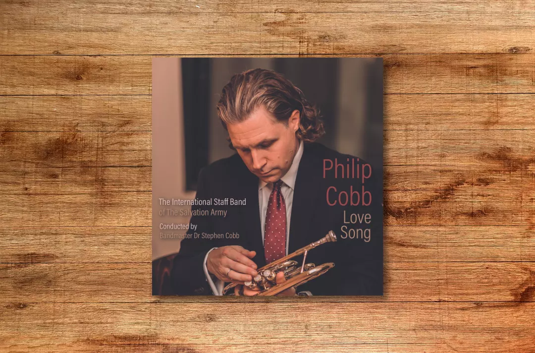 Image shows the album cover of Love Song against a wooden background.